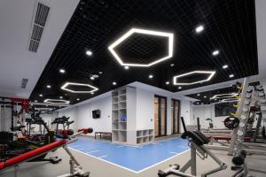 a gym with several treadmills and cardio machines at Qashqadaryo Hotel Olympic Village in Tashkent