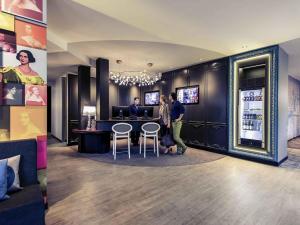 two people standing at a bar in a restaurant at Mercure München am Olympiapark in Munich