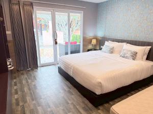 een slaapkamer met een groot bed en een groot raam bij All Times Pool Villas in Ban Tha Khun +38 foto's