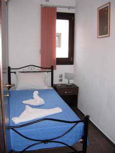 un dormitorio con una cama con una toalla de cisne en Aurora, en Platanias