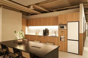 a large kitchen with a table and a refrigerator at Monrêve Cabins 몽헤브캐빈즈 in Seoul
