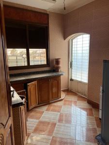 een keuken met houten kasten en een groot raam bij espace familiale in Azrou