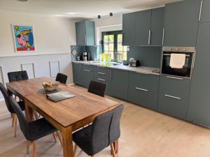 a kitchen with a wooden table and a dining room at Ferienhaus 26 Bernd mit 10-Schlafzimmer in Greifswald in Heilgeisthof