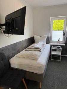 a bedroom with a bed and a flat screen tv at Ferienhaus 26 Bernd mit 10-Schlafzimmer in Greifswald in Heilgeisthof