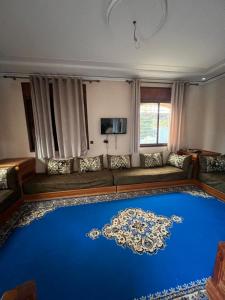 een woonkamer met een bank en een blauw tapijt bij espace familiale in Azrou