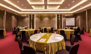 玛琅Gets Hotel Malang的一间配有桌椅和屏幕的会议室 更多199张照片