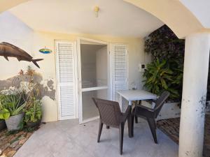 un patio con tavolo, sedie e piante di Casa Djarmai Apartments a Vila do Maio