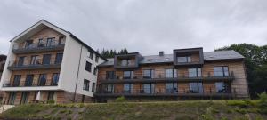 a large building with a white building at Apartmán Nest Brčálník in Železná Ruda +10 photos