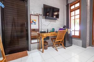 een thuiskantoor met een houten bureau en een televisie bij G Beach Hotel in Grajagan
