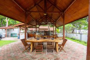 een grote houten tafel en stoelen in een paviljoen bij G Beach Hotel in Grajagan