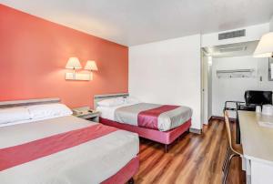 a hotel room with two beds and orange walls at Motel 6-Medford, OR in Medford