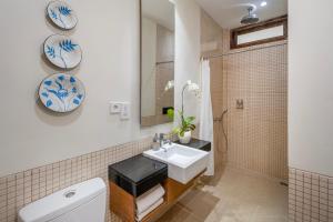 une salle de bains avec lavabo, toilettes et miroir dans l'établissement Pondok Sari Kuta, à Kuta 24 autres photos