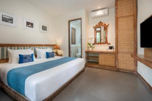 une chambre avec un grand lit et une télévision dans l'établissement Pondok Sari Kuta, à Kuta