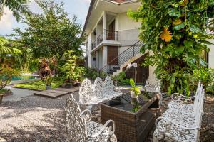 un groupe de chaises blanches devant un bâtiment dans l'établissement Pondok Sari Kuta, à Kuta