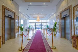 a hallway with a red carpet in a building at Al Khulfaa Al Masy - فندق الخلفاء الماسي in Makkah