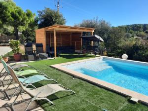 une piscine avec des chaises et un gazebo dans l'établissement Andreini Patricia et Bruno, à Draguignan