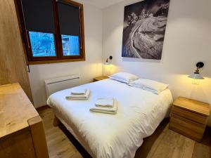 een slaapkamer met een groot bed met handdoeken erop bij Le Refuge d'Ours, Champagny in Champagny-en-Vanoise +24 foto's