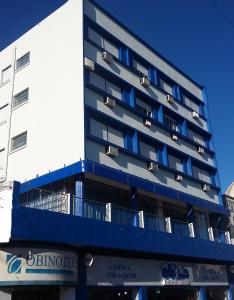 a building with blue balconies on the side of it at Hotel Obino in São Gabriel