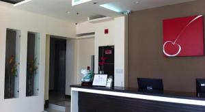 an office with a reception desk with a heart painting on the wall at Cherry Midtown Hotel in Bahac-bahac