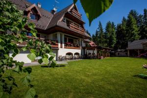 a house with a green lawn in front of it at Willa Baciarka in Kościelisko