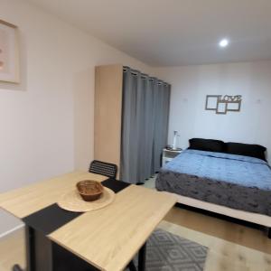 ein Schlafzimmer mit einem Bett und einem Tisch mit Hut darauf in der Unterkunft Riverside in Montereau-faut-Yonne