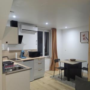 eine kleine Küche mit einem Waschbecken und einem Tisch in der Unterkunft Riverside in Montereau-faut-Yonne + 7 Fotos