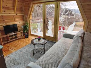 a living room with a couch and a large window at Camp Magic View in Mojkovac