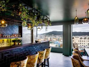 a bar with chairs and a view of a city at Mövenpick Hotel Wellington in Wellington
