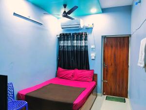 een kamer met een bed met roze lakens en een plafond bij ASSHAPPYSTAYINN HOTEL in Tiruchchirāppalli
