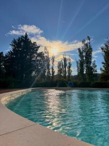 a swimming pool with the sun setting in the background at Hotel PentHouse in Perugia