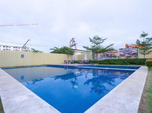 a swimming pool with blue water in a yard at Plumera Condo Near Airport Malls & Schools with Elevator125 in Lapu Lapu City +9 photos