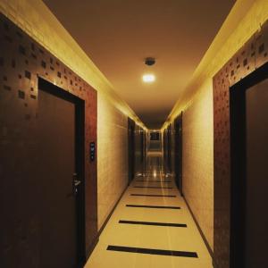 a hallway with two doors and a tile floor at Vinayaka Regency in Trivandrum +1 photo
