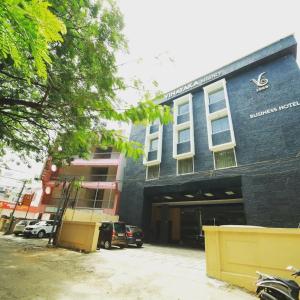 a blue building with cars parked in front of it at Vinayaka Regency in Trivandrum