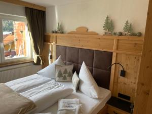 een slaapkamer met een bed met witte lakens en kussens bij Haus Romantika in Schattwald