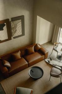 een woonkamer met een bruine bank en een tafel bij NiiRA in Mirissa