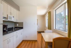 a kitchen with white cabinets and a table and a window at Motel 6-Pueblo, CO - I-25 in Pueblo