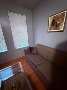 een woonkamer met een bank en twee ramen bij Eagle Pamir Guest House in New Haven