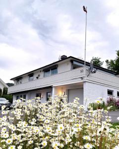 ein Gebäude mit einem Blumenfeld davor in der Unterkunft Gjesterom til leie i et privat hus in Brumunddalen