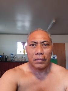 American Samoa的一个赤裸上身的男人正看着镜头。