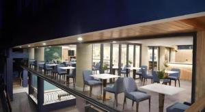 een restaurant met tafels en stoelen op een balkon bij Phattrasom Villa in Cha Am