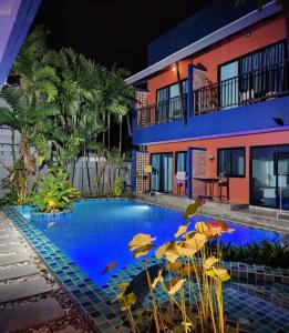 een zwembad met stoelen en parasols voor een gebouw bij Kraam Silhouette Hotel and Cafe Phuket- Chalong pier Hotel in Chalong 