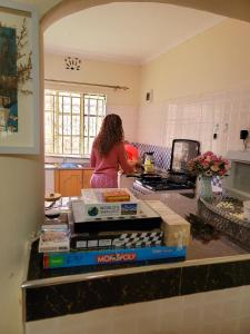 eine Frau steht in einer Küche und bereitet Essen vor in der Unterkunft Keyman Address in Nyeri