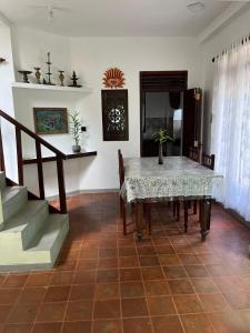 een eetkamer met een tafel en een trap bij John's Homestay in Talpe