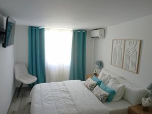 ein Schlafzimmer mit einem Bett und einer Couch und einem Fenster in der Unterkunft L'Etage 1 2 in Pointe-à-Pitre