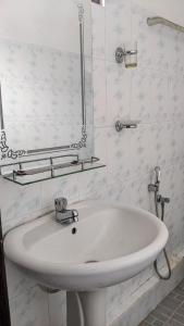 een witte badkamer met een wastafel en een spiegel bij The Shilpa Villa in Unawatuna