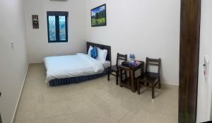 een slaapkamer met een bed, een bureau en een tafel met stoelen bij Hoa Lu Garden Resort in Ninh Binh +212 foto's