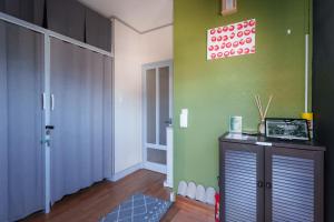 een kamer met een groene muur, een kast en een deur bij 富士吉田たまきや in Fujiyoshida