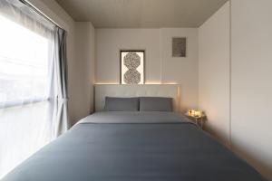 a bed in a bedroom with a large window at Peace 平和屋 in Osaka