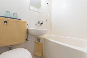 a bathroom with a sink and a toilet and a tub at Peace 平和屋 in Osaka