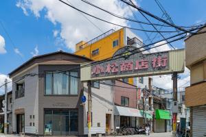 a building with a sign on the side of a street at Peace 平和屋 in Osaka